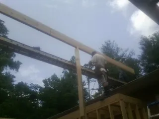 Carpenter setting a ridge beam over a new addition frame — Ice Dam Removal by Roofing Brothers in Beech Grove