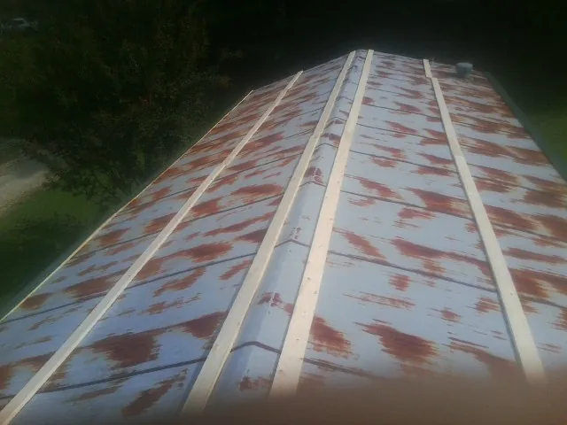 Rusted metal roof panels with new wood purlins before replacement — Storm Damage Roof Repair in Beech Grove by Roofing Brothers