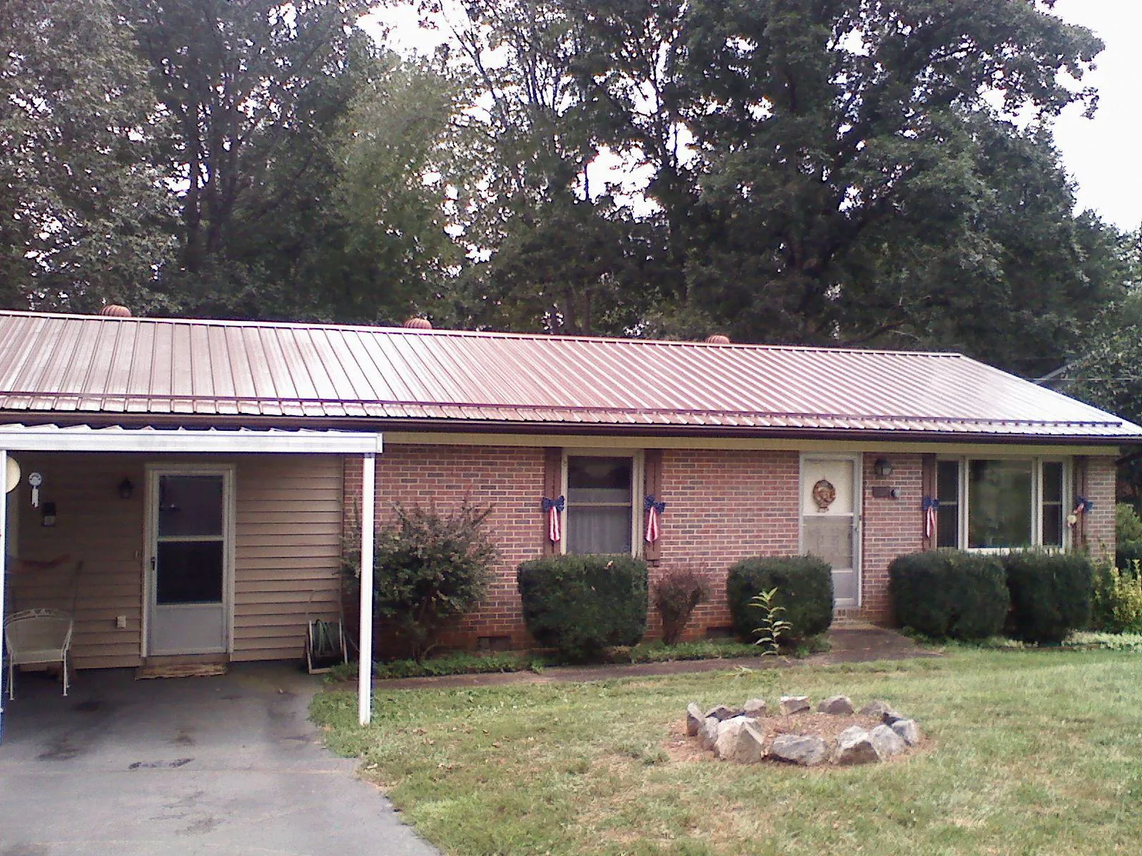 Bronze metal roof and carport on a brick ranch home — Roof Repair work by our crew in Beech Grove